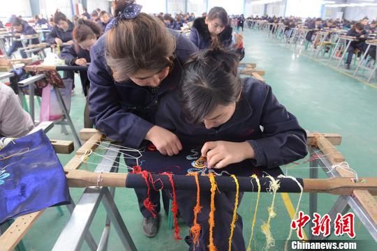 3月29日，工人们在喀什丝路行科技研发有限公司刺绣产业扶贫车间中上班。　勉征 摄
