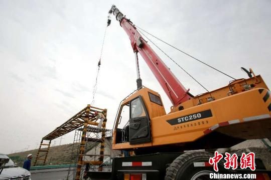新疆奎屯市拆除道路限高架，确保冷箱运输货车通过。　吴长占 摄