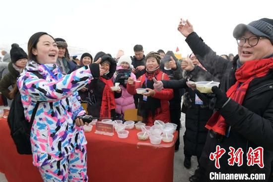 18日，新疆福海县第十四届冬捕节现场，为来自各地的游客准备了一个“新年福锅”，吸引游客品尝。　岩上松 摄