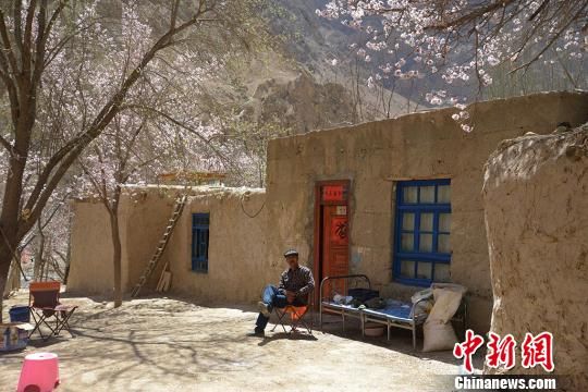 4月3日，坐在自家院中享受春光的村民。　勉征　摄