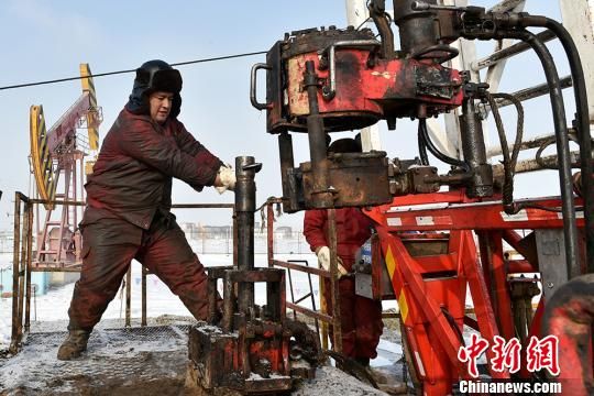 石油工人们正在白雪皑皑的井场修井作业。　闵勇　摄