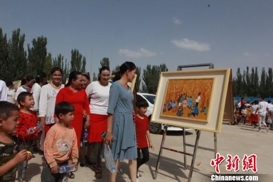 新疆维吾尔自治区文化馆25日为新疆墨玉县喀瓦克乡农民举办新时代下图片展活动。　陶拴科　摄