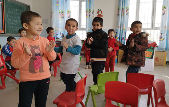 孩子们穿上爱新衣服在教室玩耍。