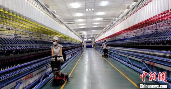 新疆某棉纺有限公司各车间生产稳定有序，纺织工人正在车间作业。　曹莉　摄
