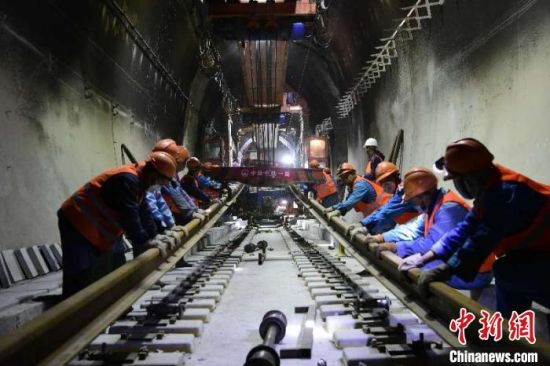中国中铁一局格库铁路(新疆段)项目部铺架队正在阿尔金山隧道内铺轨。　陈剑飞 摄