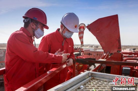 新疆油田科研人员查看油井压裂施工现场情况。　张昀　摄