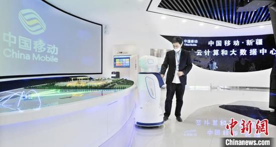 中国移动（新疆）云计算和大数据中心的员工正在操作机器人。约提克尔·尼加提